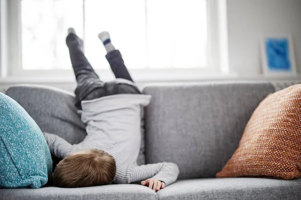 Söta barn liggande ansikte ner på soffan — Stockfoto