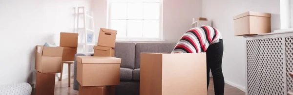 Femme à l'intérieur d'une boîte tout en se préparant à déménager dans une nouvelle maison. — Photo