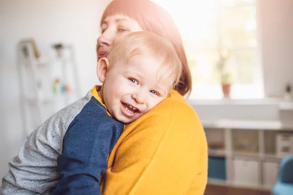 Счастливая мать обнимает своего улыбающегося сына. — стоковое фото