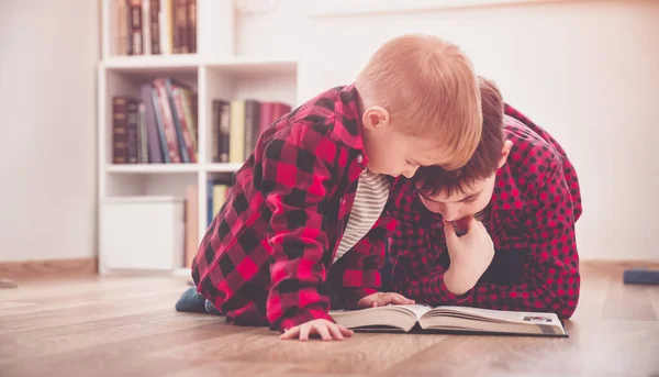 Drie jaar oud kind zit tussen de boeken thuis — Stockfoto