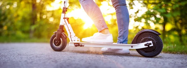 Donna che cavalca su scooter in parco in estate — Foto Stock