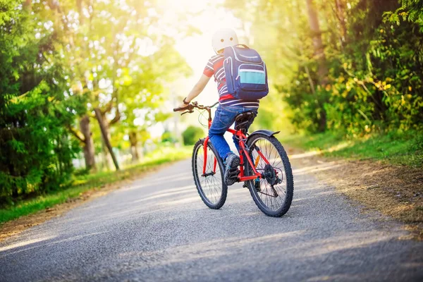 Tiener op de fiets op de asfaltweg rijden naar de school — Stockfoto