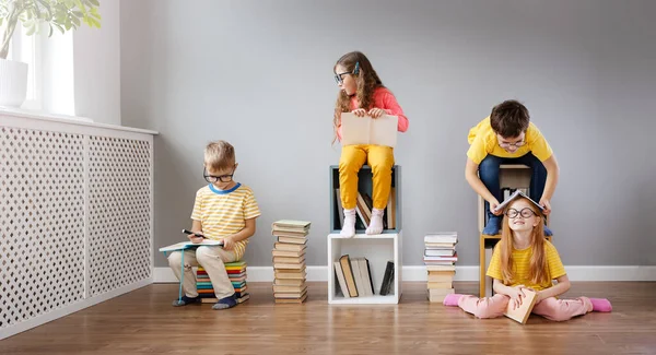 Groupe d'enfants assis dans la chambre et lisant des livres. — Photo