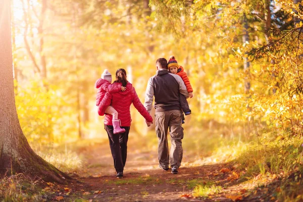 Familjen vandrar längs stigen i höstens naturpark — Stockfoto