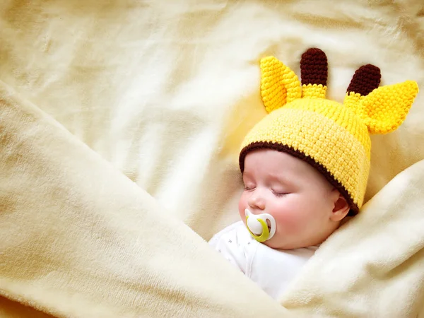 Baby schläft in Giraffenmütze — Stockfoto