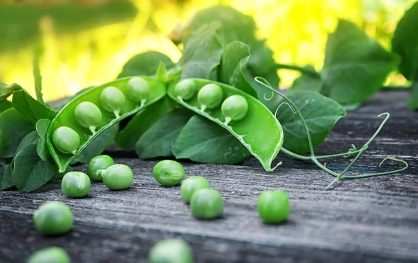 Guisantes sobre fondo de madera — Foto de Stock