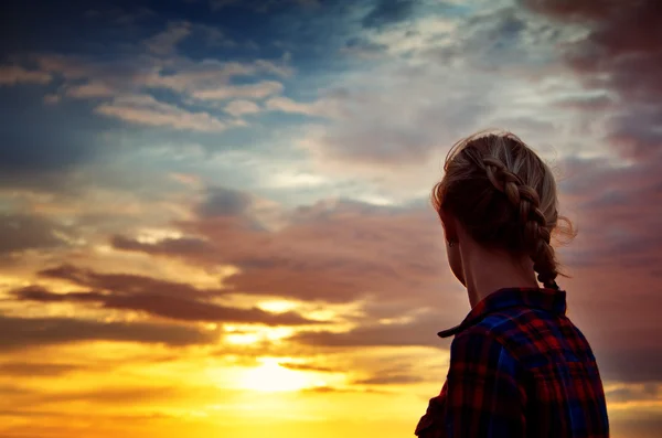 Jovem mulher olhando para o pôr do sol — Fotografia de Stock