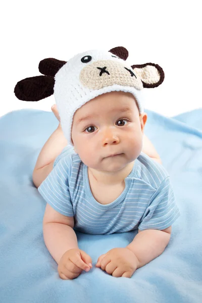 Baby in a cow hat on blue blanket — Stock Photo, Image