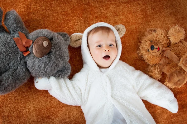 Pequeno bebê no traje de urso com brinquedos de pelúcia — Fotografia de Stock