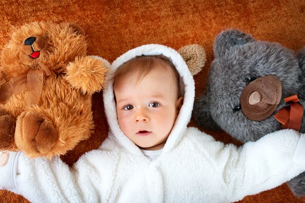 Pequeno bebê no traje de urso com brinquedos de pelúcia — Fotografia de Stock