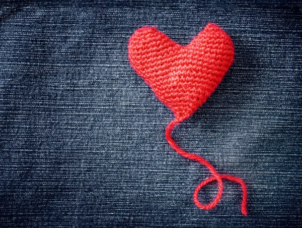 Πλεκτό καρδιά σε φόντο μπλε τζιν υφή — Φωτογραφία Αρχείου