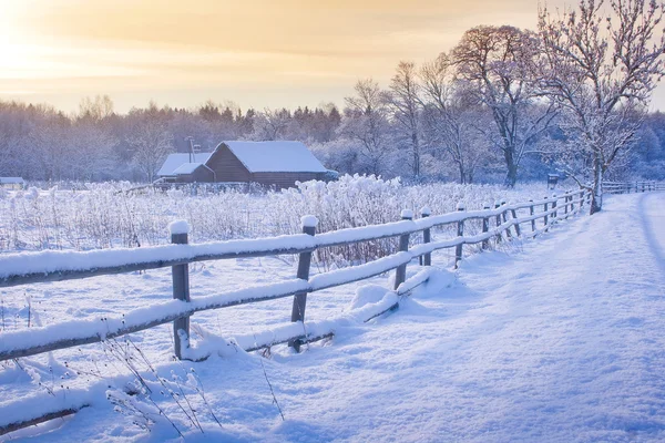 Landelijk huis met een hek in de winter — Stockfoto