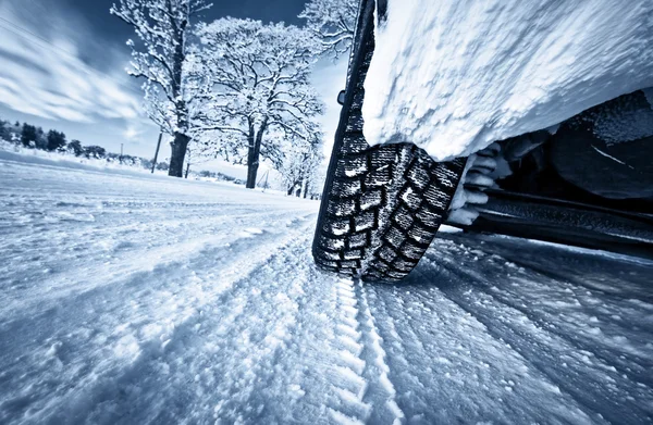 Pneus de carro na estrada de inverno — Fotografia de Stock