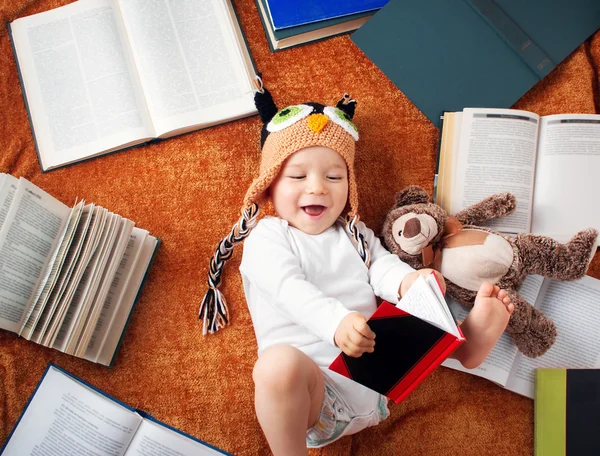 Bebé de un año leyendo libros con osito de peluche — Foto de Stock