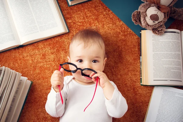 Um ano de idade bebê com óculos e um ursinho de pelúcia — Fotografia de Stock