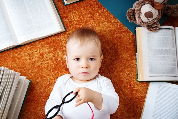 Un bébé d'un an avec des spectacles et un ours en peluche — Photo