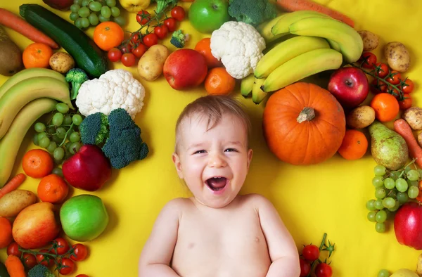Baby surrounded with fruits and vegetables — Stock Photo, Image