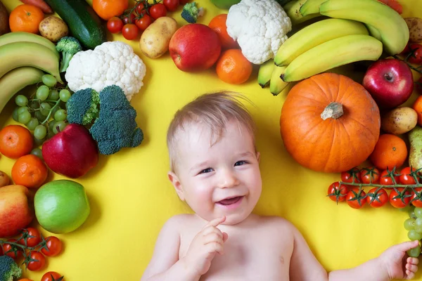 Bebê cercado de frutas e legumes — Fotografia de Stock