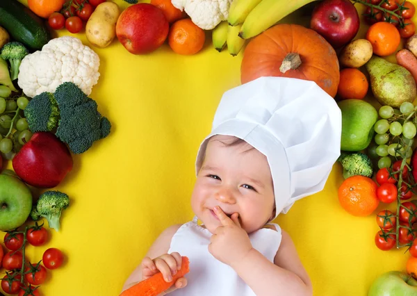 Bebê cercado por frutas e legumes — Fotografia de Stock