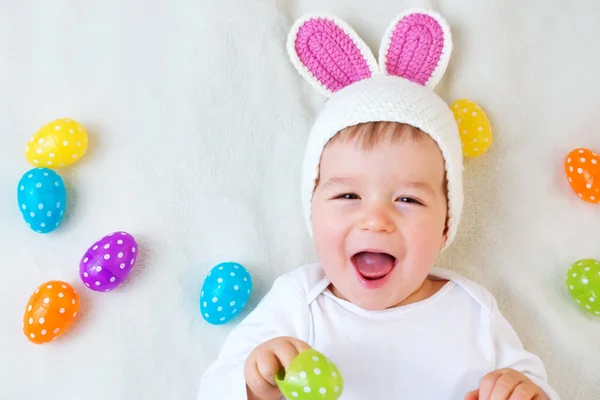 Babyjongen in bunny hoed liggend op groene deken met Pasen eieren — Stockfoto