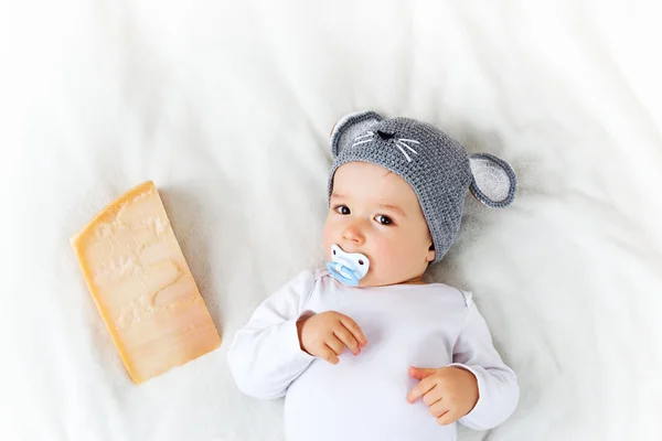 Junge mit Mäusemütze liegt auf Decke mit Käse — Stockfoto