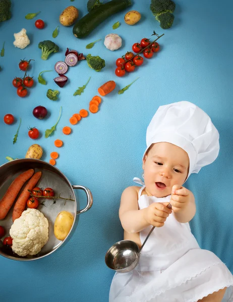 Niño en sombrero de chef con sartén y verduras —  Fotos de Stock
