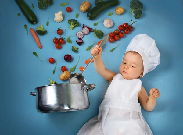 Niño en sombrero de chef con sartén y verduras — Foto de Stock