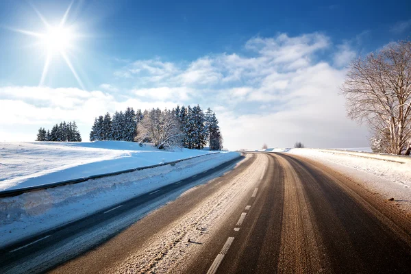 Asfaltová silnice v zasněžené zimě na krásný slunečný den — Stock fotografie