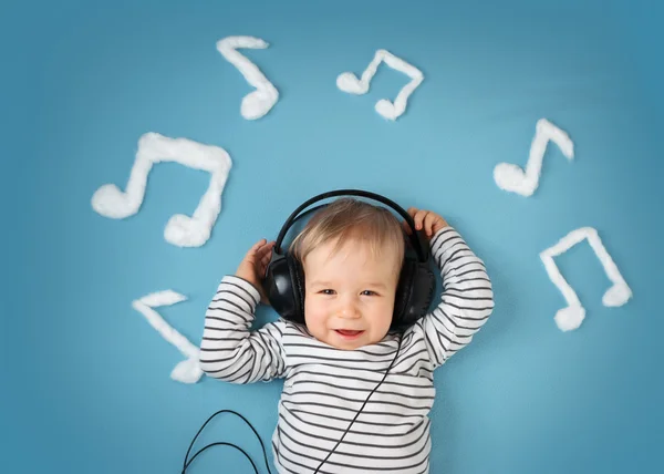 Mały chłopiec na tle niebieski koc ze słuchawkami — Zdjęcie stockowe