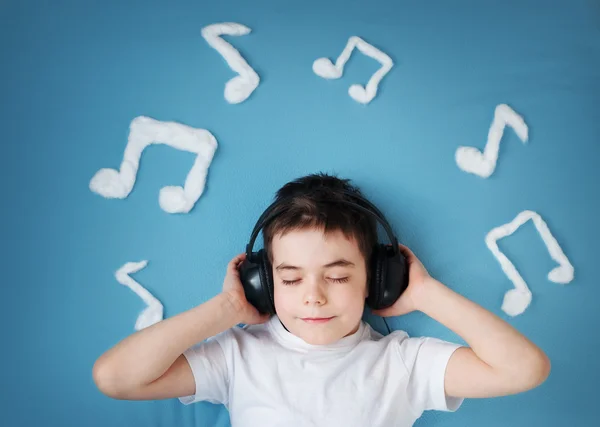 Chłopiec na tle niebieski koc z słuchawki — Zdjęcie stockowe
