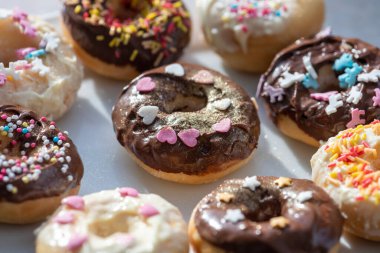 Çikolata ve renkli şekerlerle kaplı lezzetli çörekler. Sevgililer Günü ve doğum günleri için kalpler. Aşıklar için tatlılar.