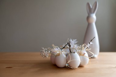 Arka planda Paskalya tavşanı ve ön planda beyaz yumurtalar Paskalya için dekorasyon fikri. Peyzaj biçimi.