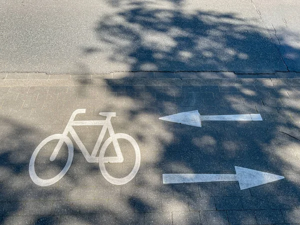 Oznakowanie na ścieżce rowerowej, symbol rowerowy ze strzałkami w prawo i w lewo. — Zdjęcie stockowe