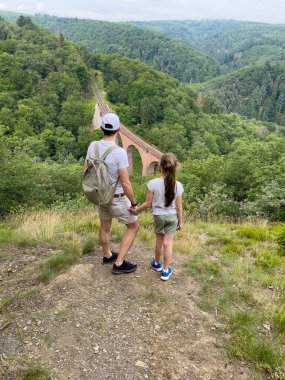 Bir adam ve bir çocuk dağın tepesinde duruyor.