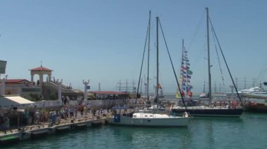 Limanda Yatlar ayakta ve gemi yelken ile insanlar yürümek