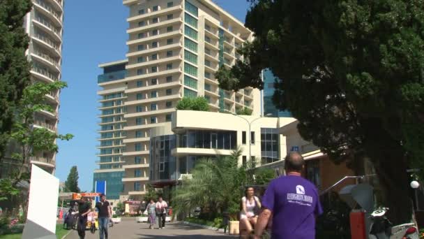 Fotgängare gå längs strandpromenaden i staden på en solig sommardag — Stockvideo