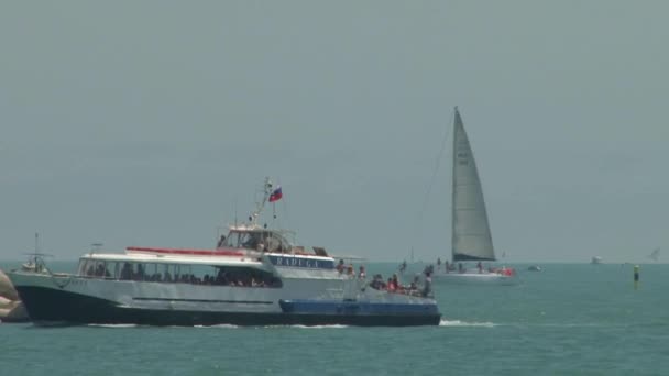 Barco de prazer passa pelo farol no fundo — Vídeo de Stock