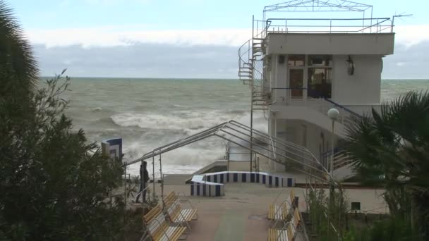 Um jovem montando uma scooter no passeio marítimo durante uma tempestade no Mar Negro — Vídeo de Stock