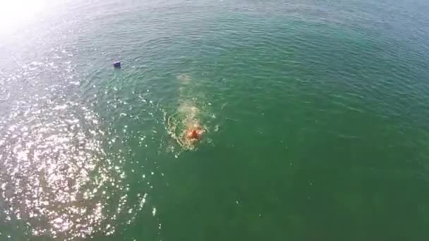 Homem mergulha no mar tiro do ar — Vídeo de Stock