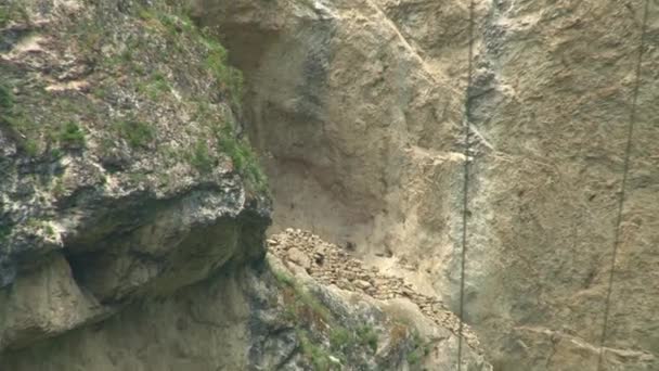 Kurtat Gorge in Noord-Ossetië. De overblijfselen van de middeleeuwse gebouwen in de grot. — Stockvideo