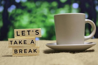 Tahta karoların seçici odak noktası metin ile Hadi bir ara verelim ve bir fincan kahve içelim. Bokeh etkisi arkaplanı