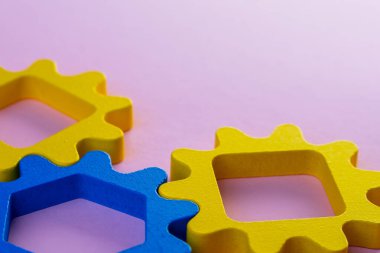Interlocking gear shapes on a pink background. Teamwork, synchronization, strategy, process, and business mechanisms concept. Copy space for text.
