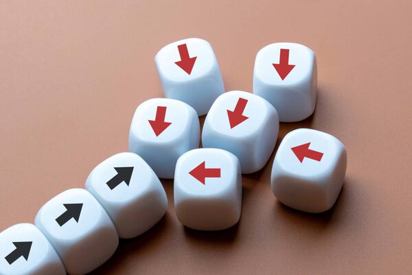 Белые кубики с красными и черными стрелками, указывающими в противоположных направлениях. Сопротивление изменениям, противоречивые направления, концепция упрямства.