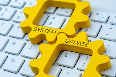 Bilgisayar klavyesinde SİSTEM UPDATE yazılı iki birbirine kenetlenmiş teçhizat. Geliştirme, bakım veya yazılım güncelleme kavramı.