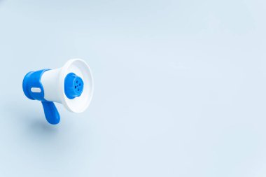 Mavi arka planda fotokopi alanı olan bir megafon. Pazarlama, duyurular, iletişim, halkla ilişkiler ve acil haber güncelleme kavramı.