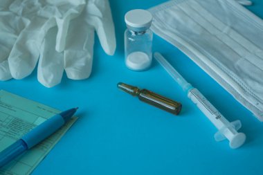 Tıbbî düzen. Aşı şişesi ve şırınga, tıbbi maske ve eldiven, reçete. Coronavirus aşısı konsepti