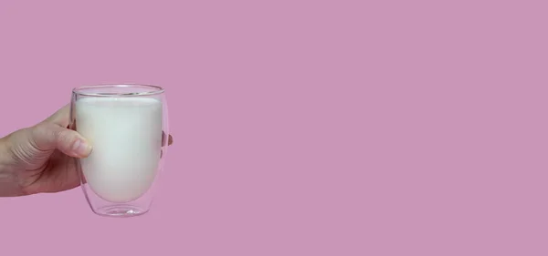 Weibliche Hand Hält Ein Glas Mit Frischer Milch Auf Rosa — Stockfoto