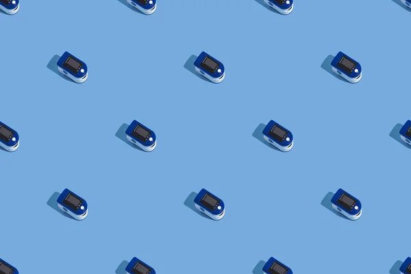 ハードシャドウのブルーの背景にポータブルパルス酸素濃度計 肺の酸素の制御 上からの眺めパターン — ストック写真