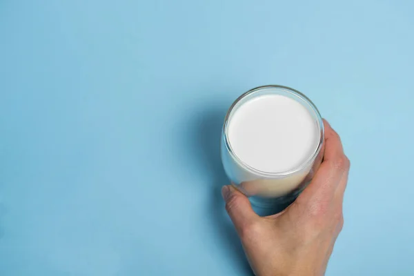 Mão Feminina Segurando Copo Com Leite Fresco Fundo Azul Bebida — Fotografia de Stock