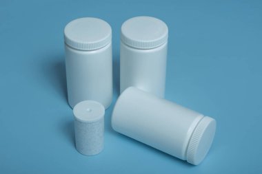 Renkli arka plan üzerinde beyaz plastik kavanozlar. Boşluğu kopyala.